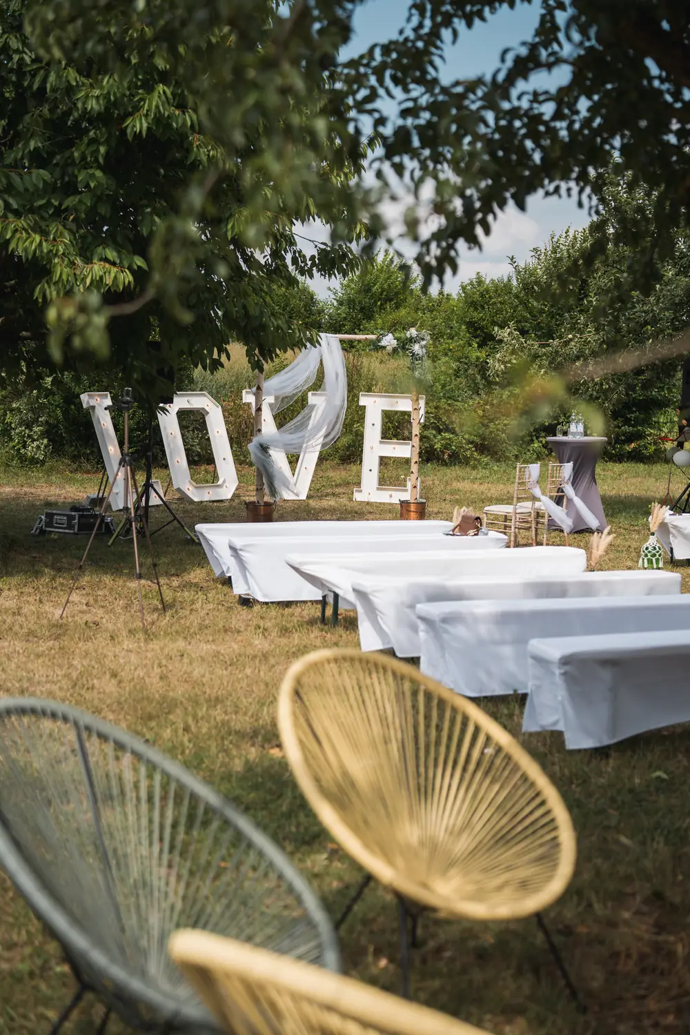 Garden reception with illuminated LOVE letters and seating areas.