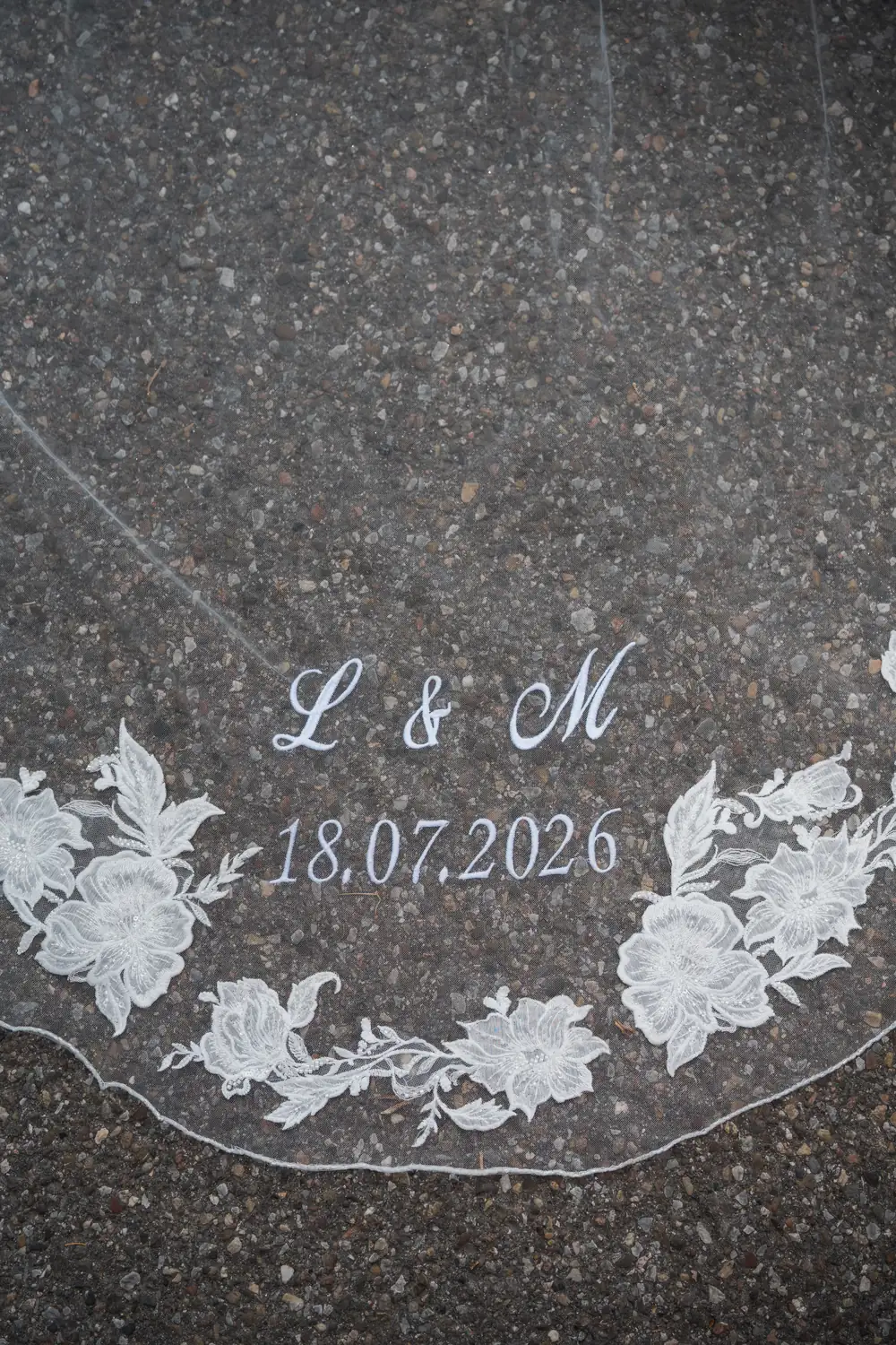 Embroidered bridal veil with the initials L and M and the date 18 July 2026.