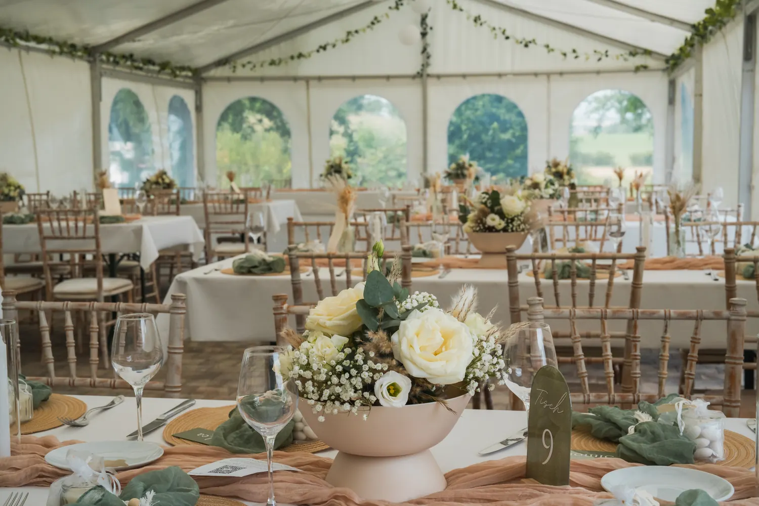 View across the set tables inside the marquee.